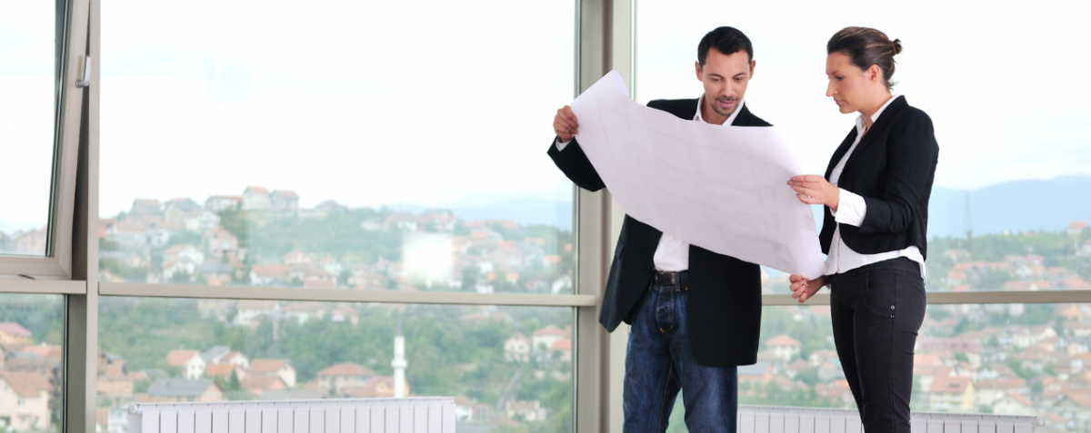 A girl and guy looking at a building plan